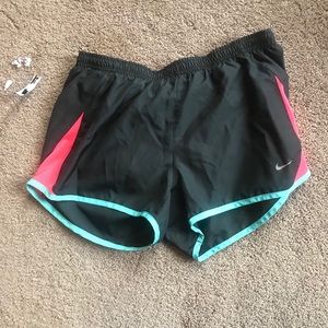 Dark grey, pink and teal blue Nike shorts.